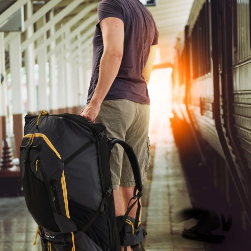 Man with fully loaded LayBakPak backpack has just stepped off a train onto platform