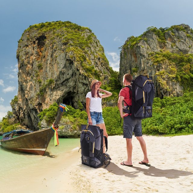 Two people with fully loaded LayBakPak backpacks having just arrived on a tropical beach