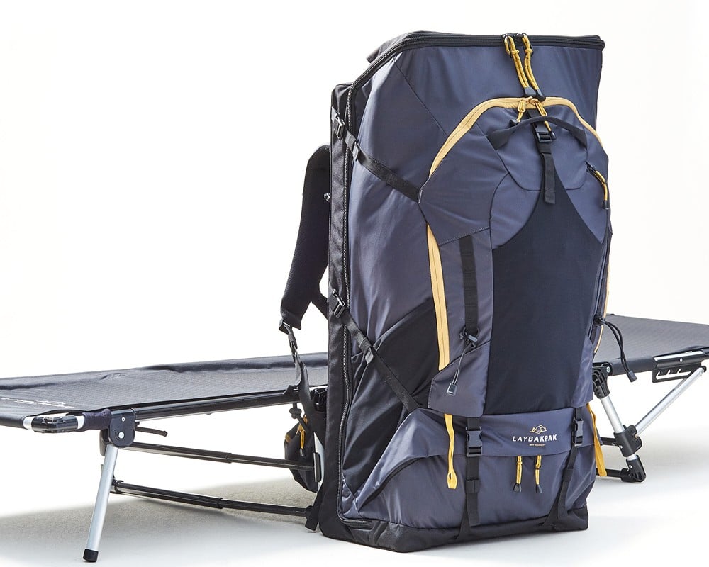 LayBakPak bed in flat position with free standing fully loaded backpack beside it