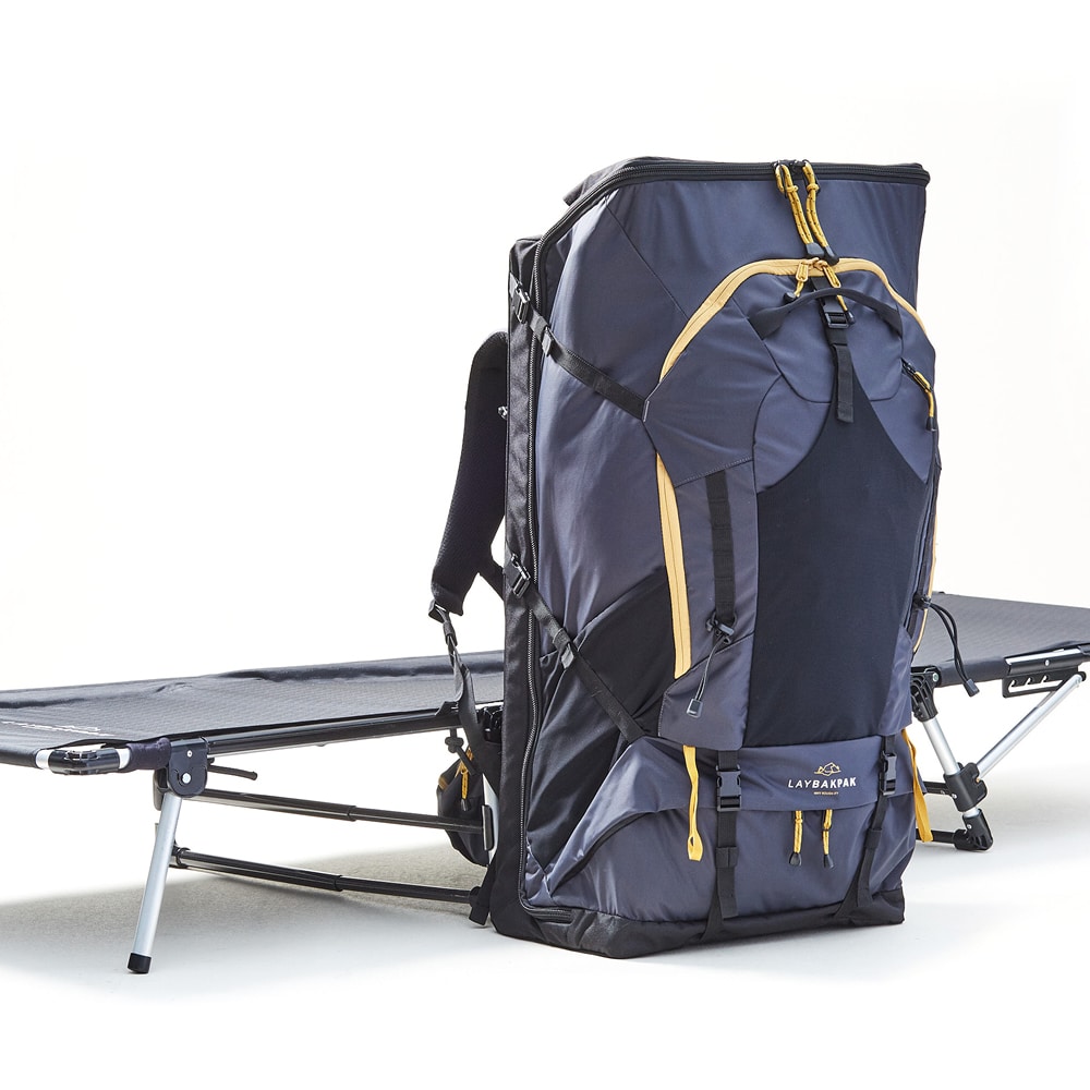 LayBakPak bed in flat position with free standing fully loaded backpack beside it